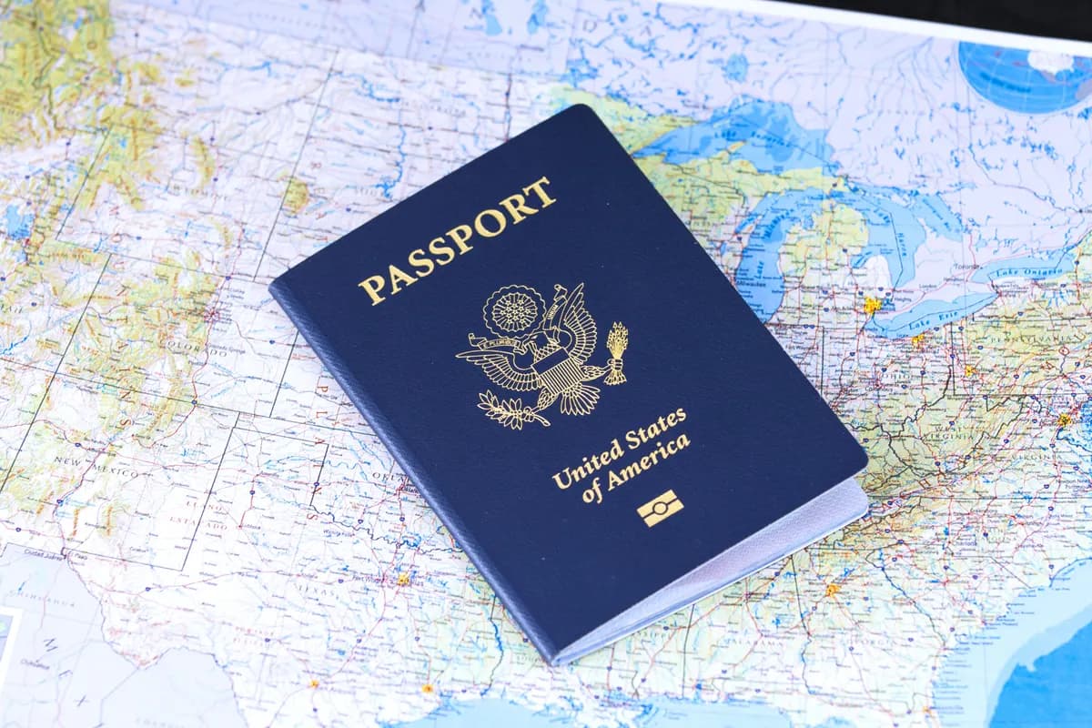 A closed passport lying on an open world map, ready to be checked before a trip
