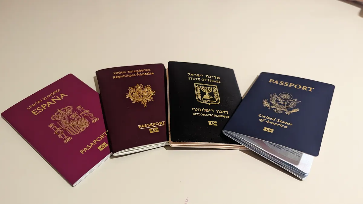 Four closed passports from different countries laid side by side on a table